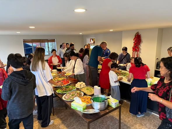 Members and families sharing food at a community meal